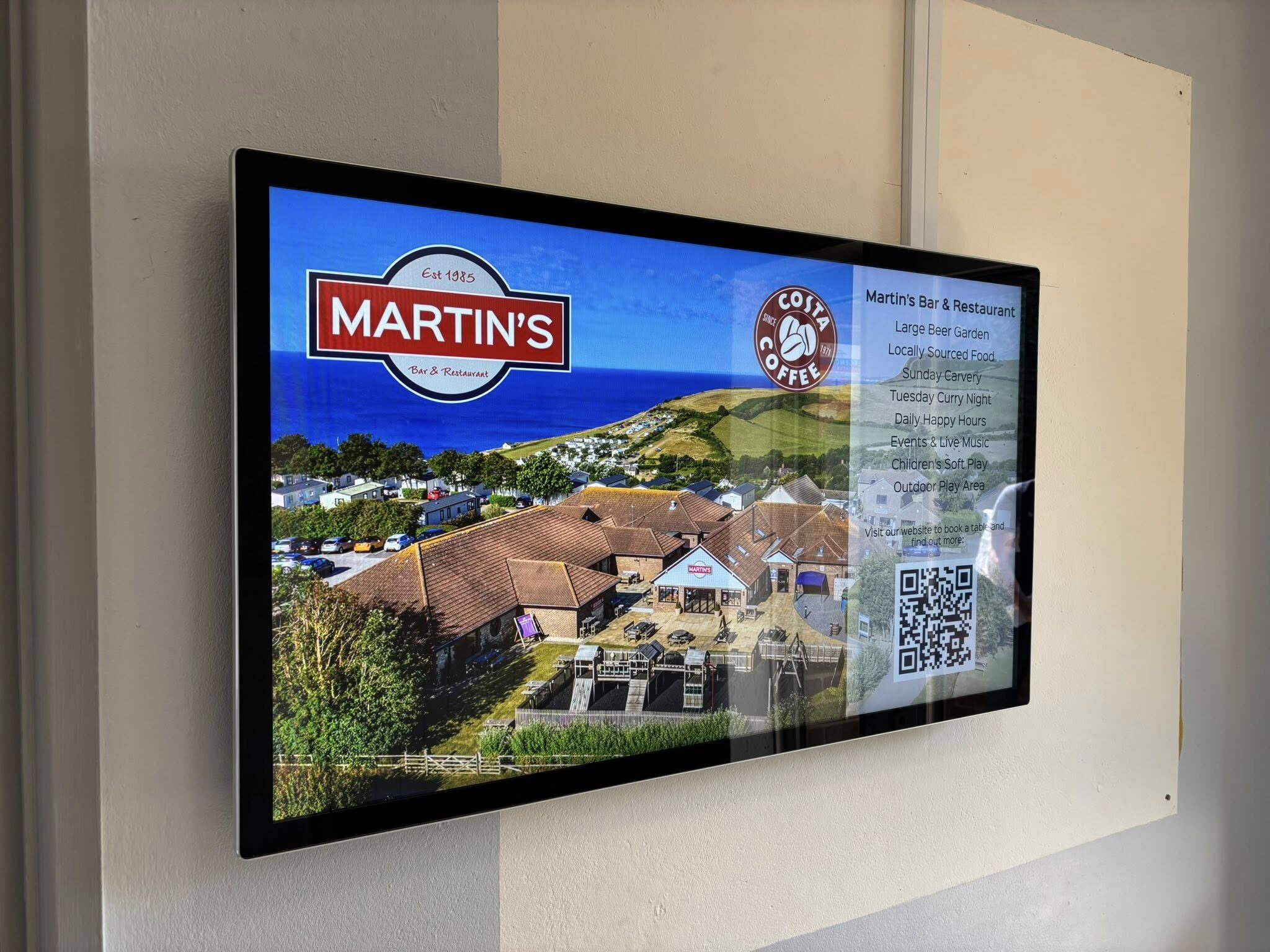 Seeview digital display in a holiday park reception showing events and offers powered by Holidaymaker Smart Surfaces software.